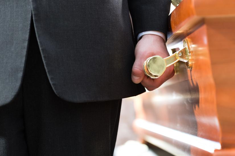 Mann hält Sarggriff